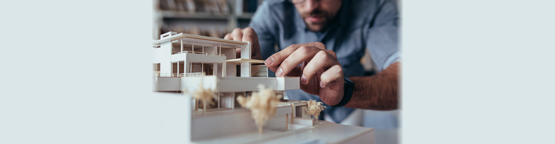 Close up of male architect hands making model house